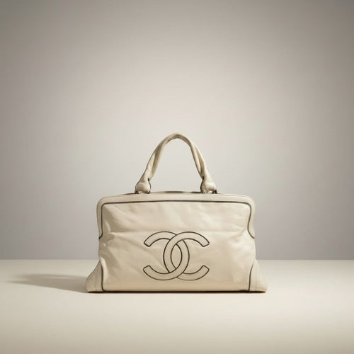 Chanel cream calfskin leather tote with stitched CC logo and silver chain detail. Top handles show wear.
